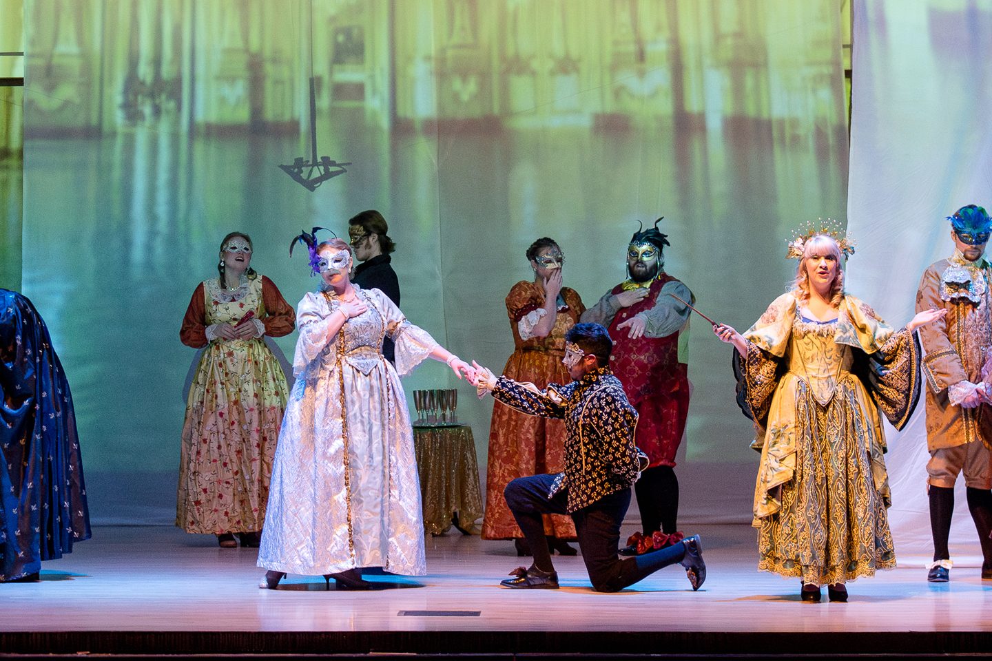 opera chorus onstage with elegant costumes