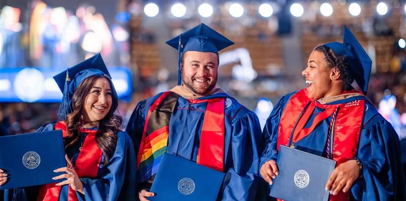 Grads showing off their diplomas after the ceremony.