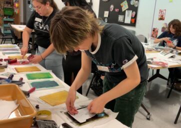 People working on art projects in a classroom.