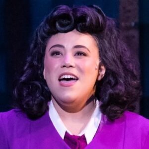 A performer in costume with a 1950s-style shoulder-length wig