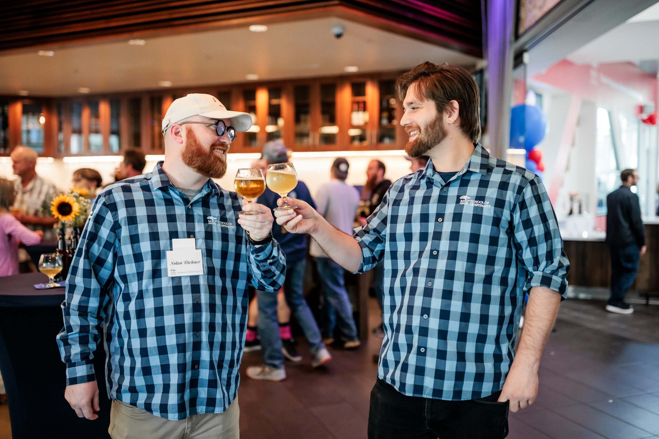 two alums drinking beer from charlie papazian grand opening