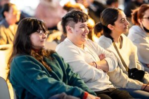 Three students listening to a lecture. 