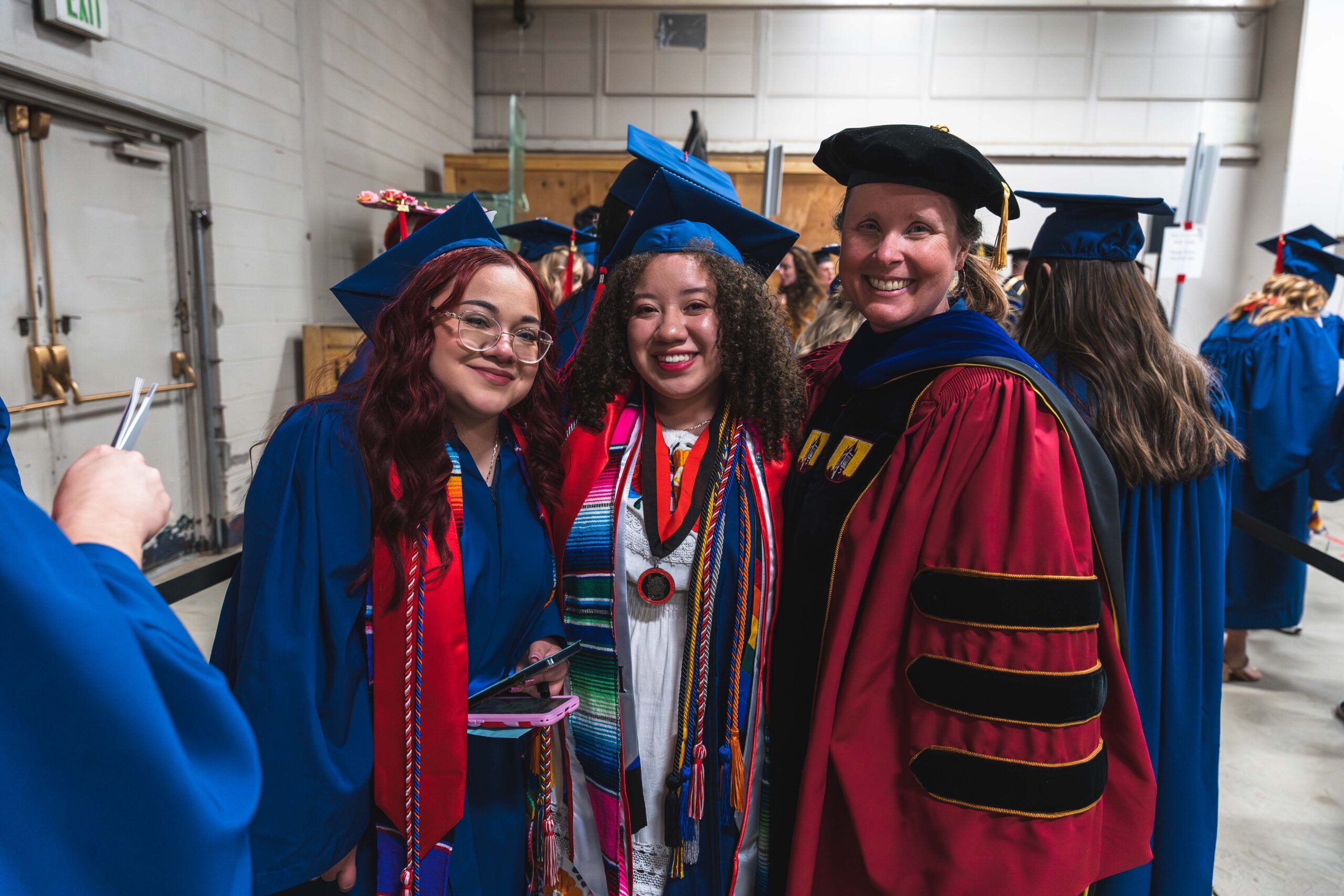 two school of hospitality graduates with their professor