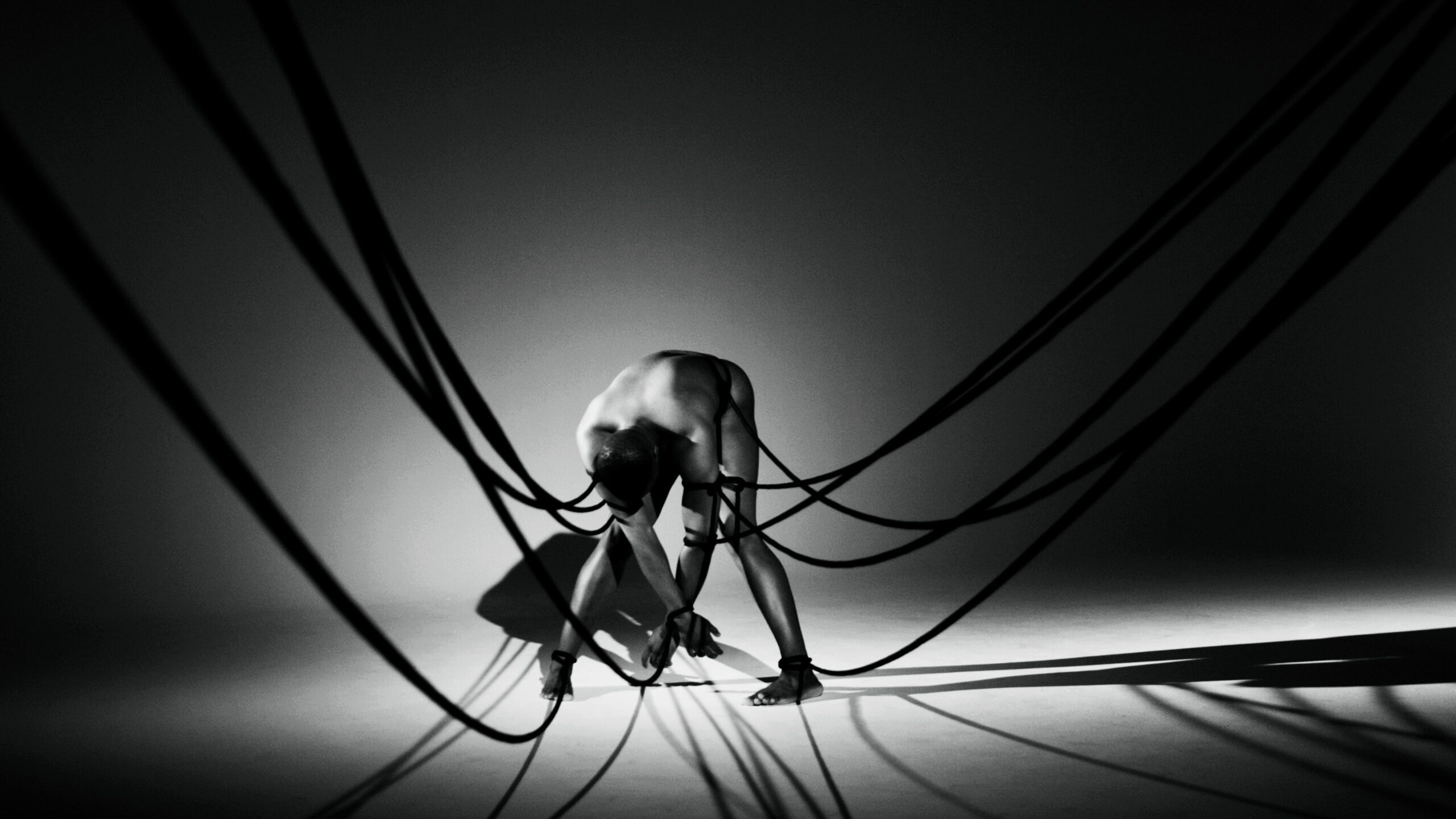 Blurred figure seen through a circular opening in a tangled net.