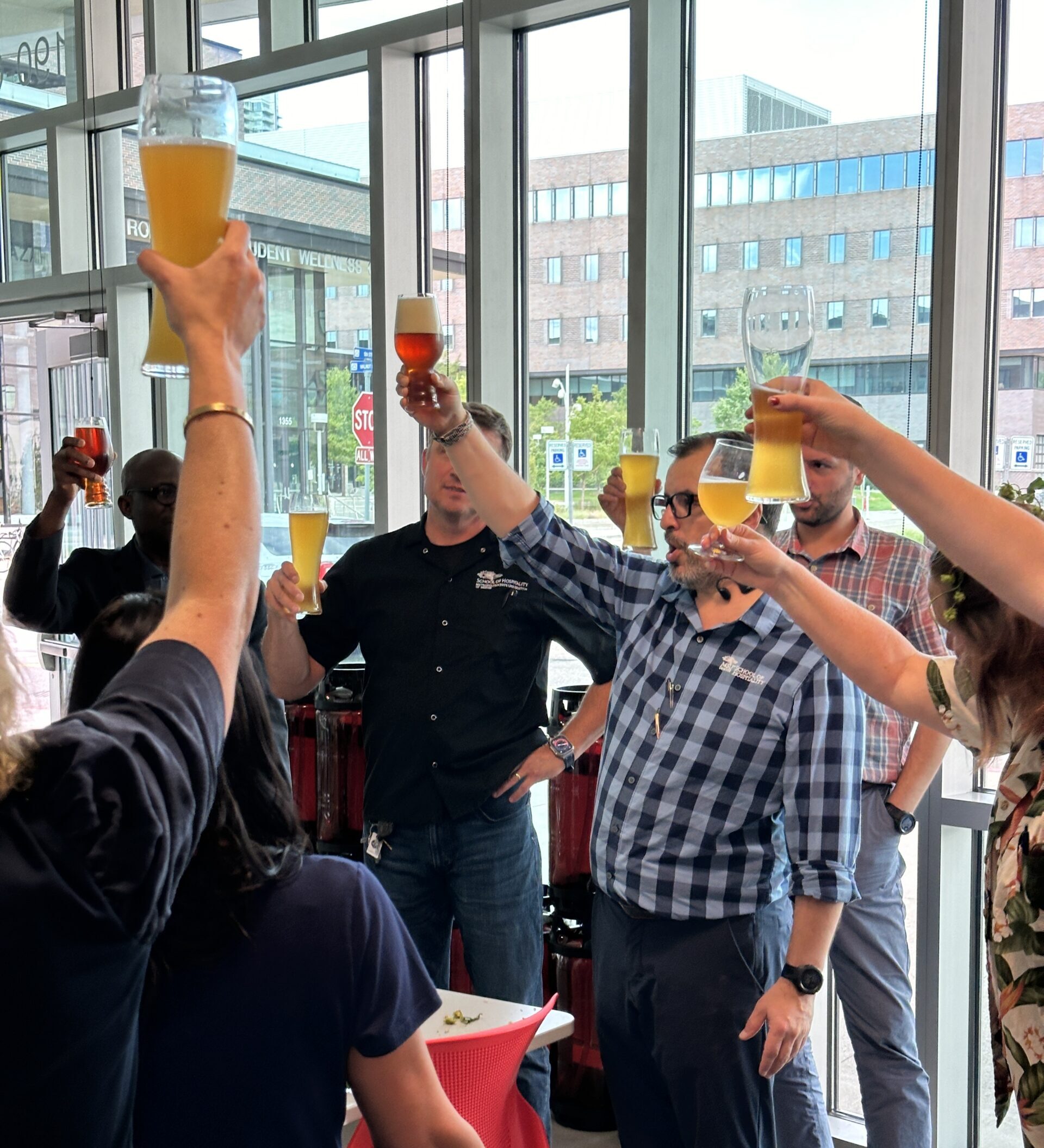 professors and faculty cheersing in the charlie papazian brewing education lab