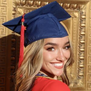 A young woman with long blonde hair wearing a blue graduation cap