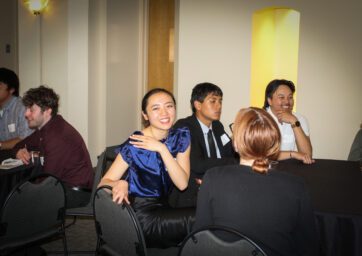 Students mingling and one smiling at the camera.
