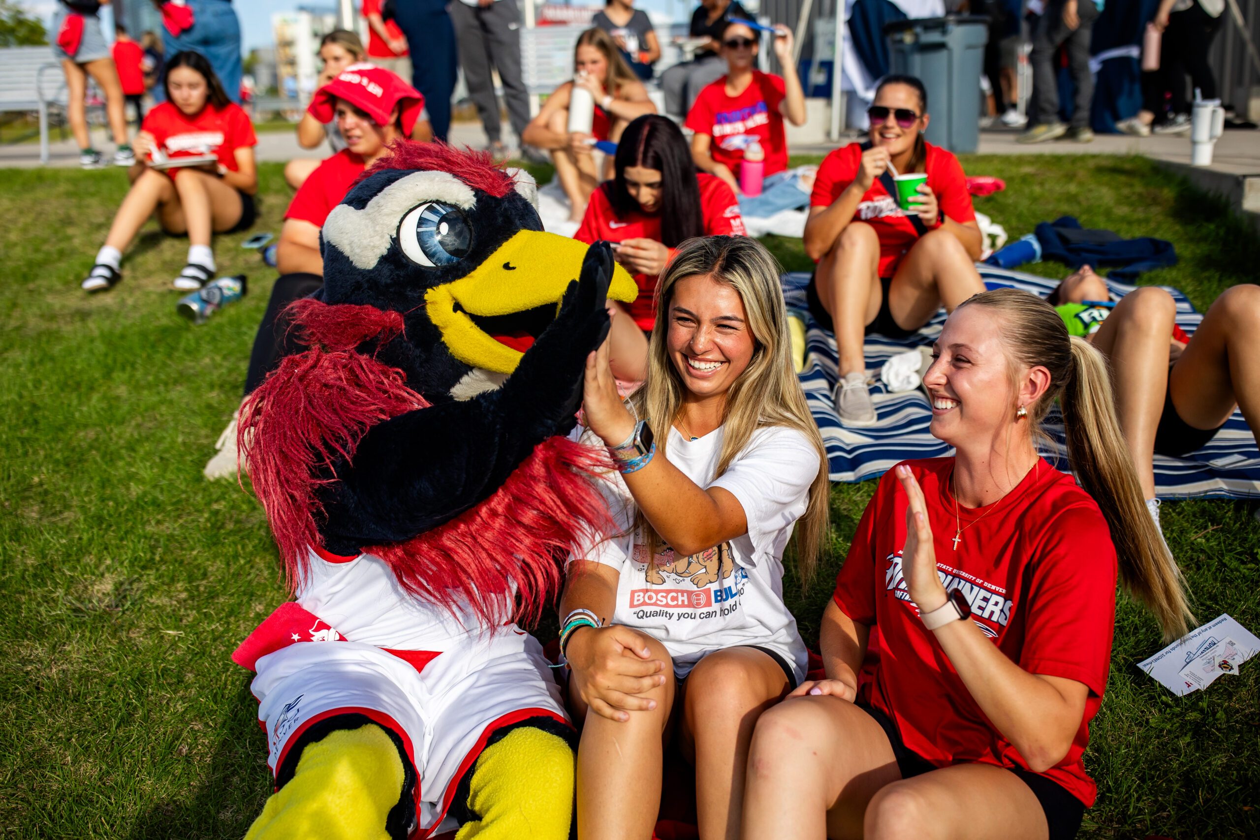 Rowdy high fives two fans who are smiling