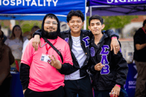 three students standing together smiling