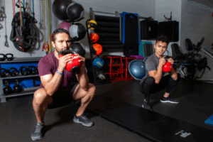 two people squatting with weights