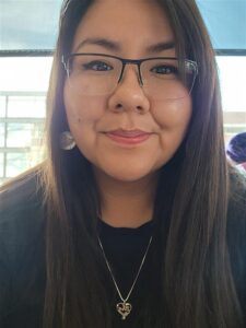 Image of Deserea Richards, wearing glasses and a black top. Deserea has long brown hair