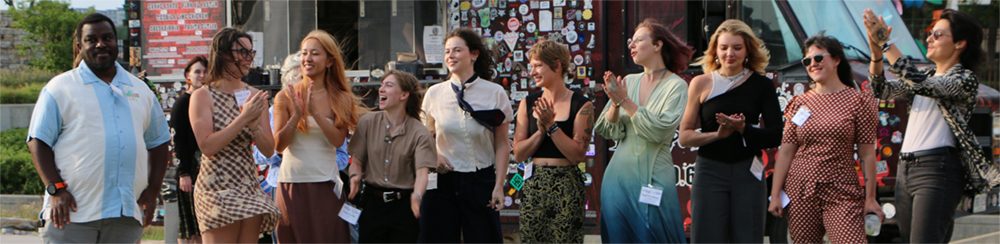 2025 Design and Build Interns and Advisors stand in a row, smiling and clapping.