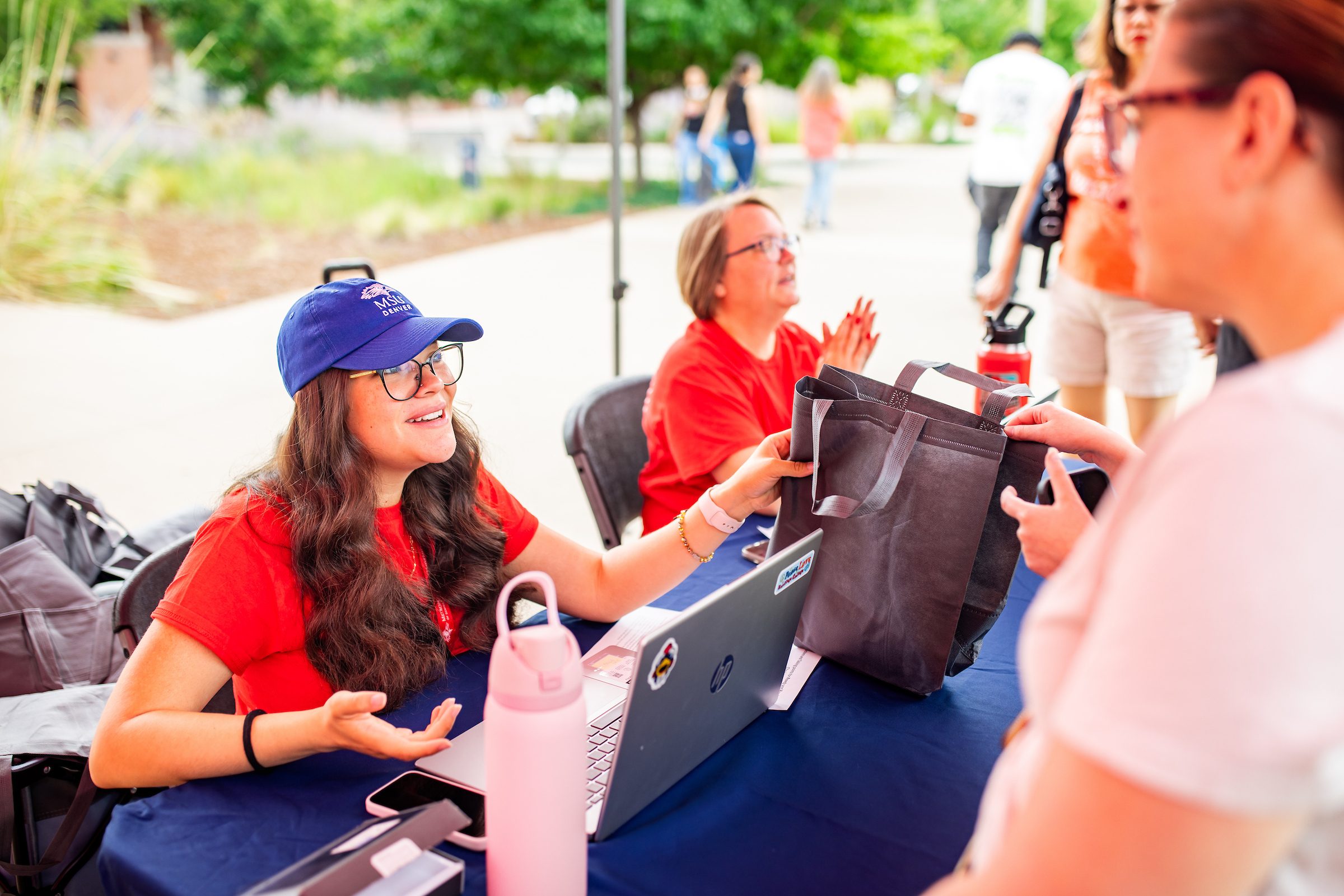 Staff talking to a student and signing up for a registration event