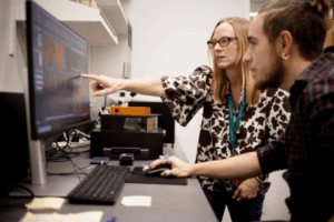 Staff member helping student on computer