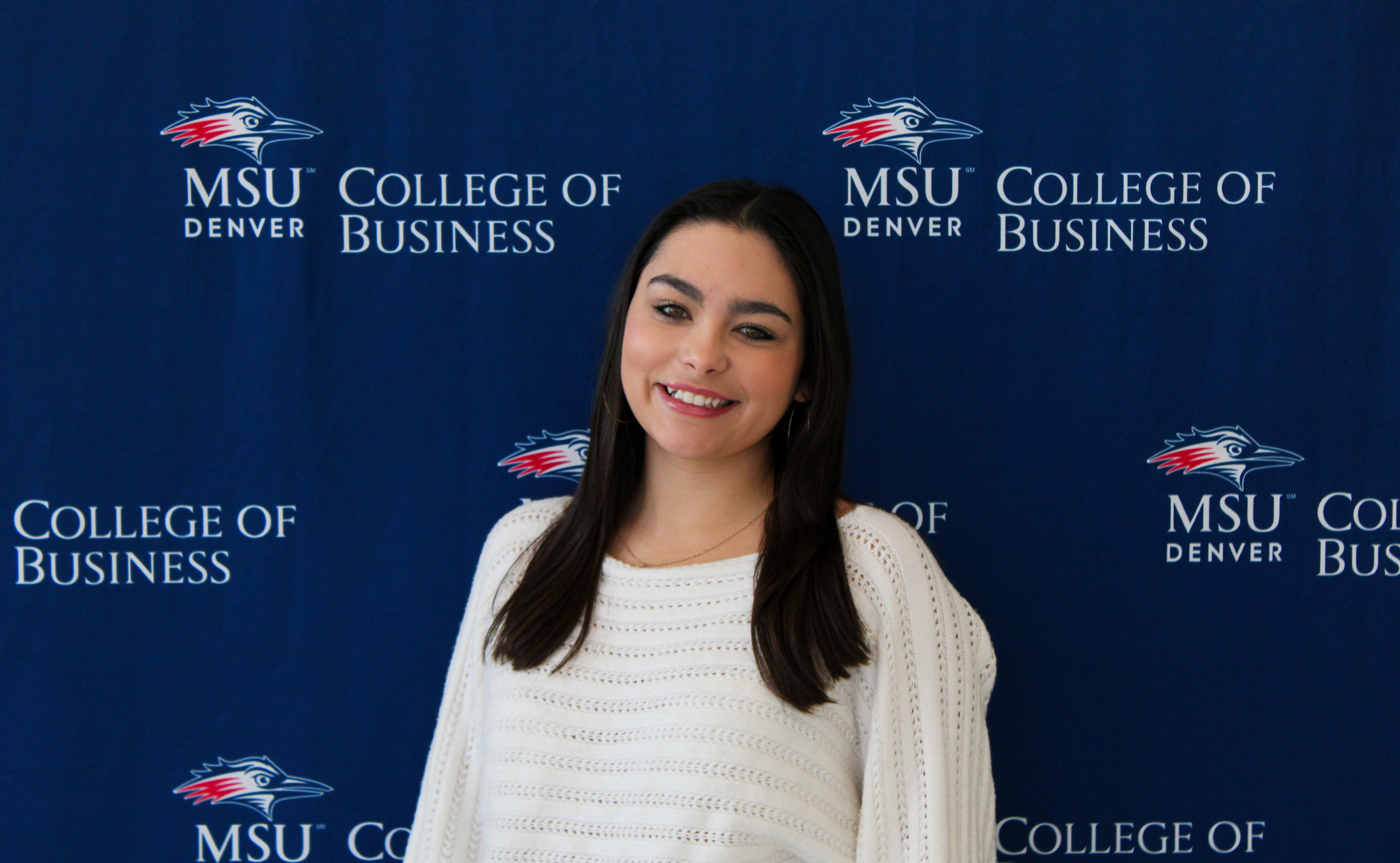 Amanda - smiling student ambassador standing in front of an MSU Denver College of Business backdrop.