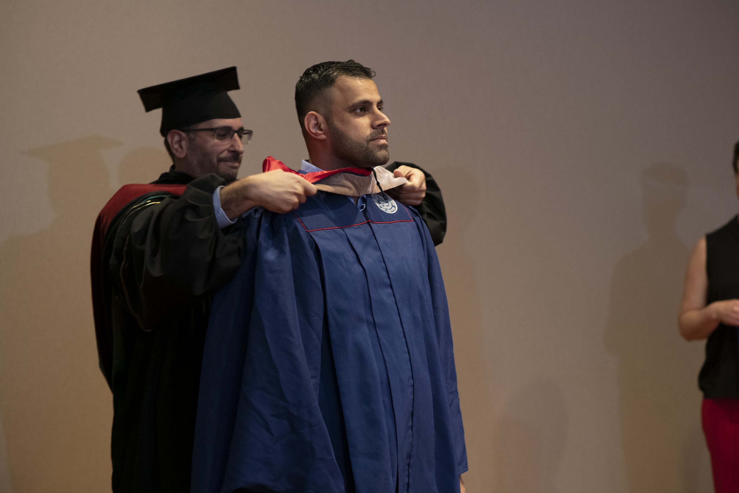 A grad is 'hooded' by a professor in the College of Business at MSU Denver.