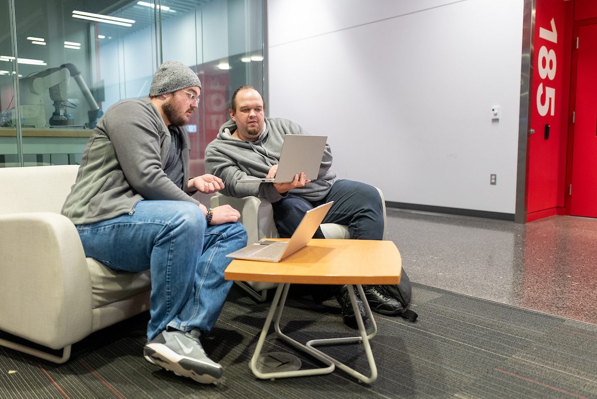 Two students looking at each others computer screens