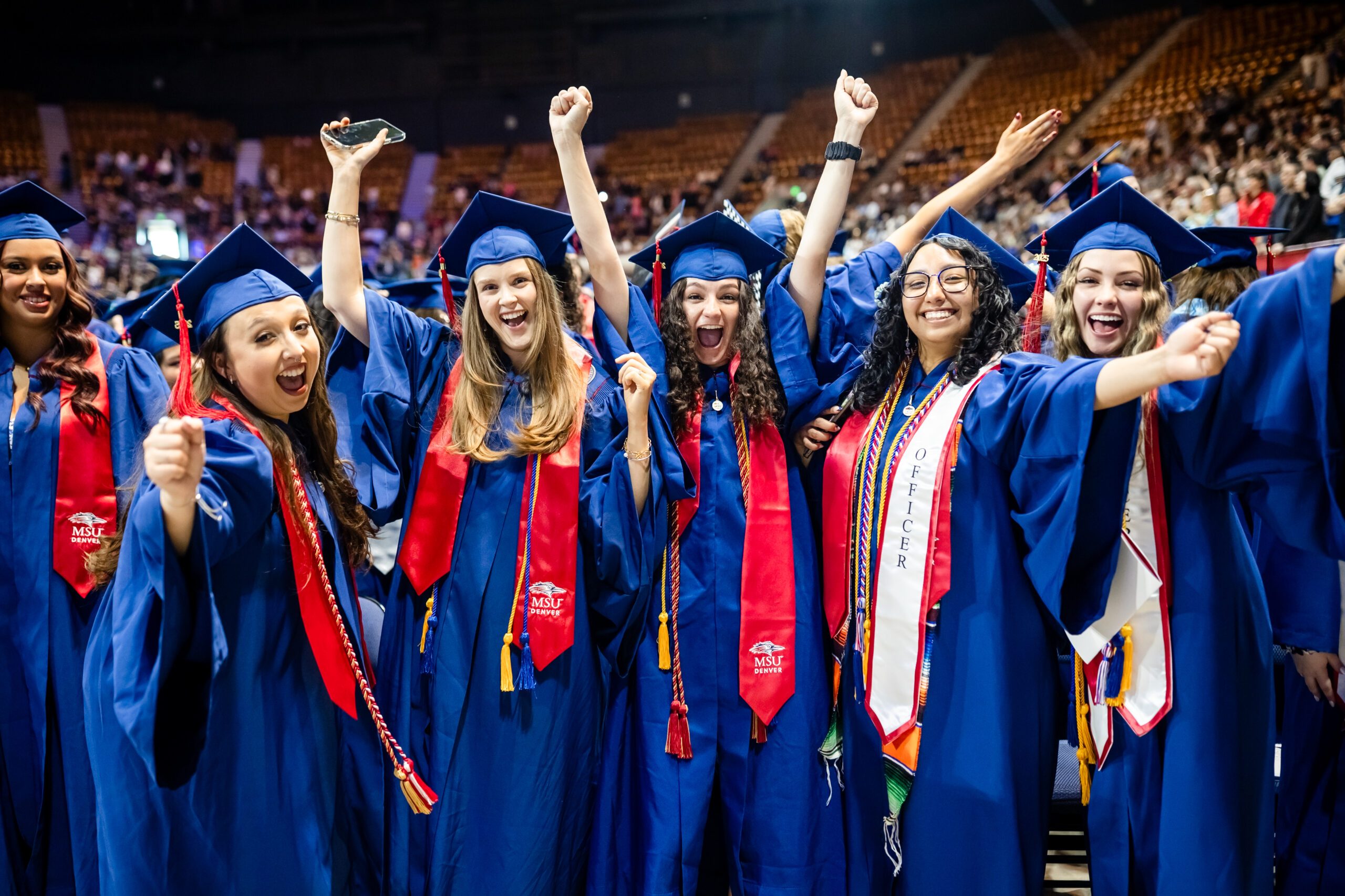 Group of students raising arms in excitement