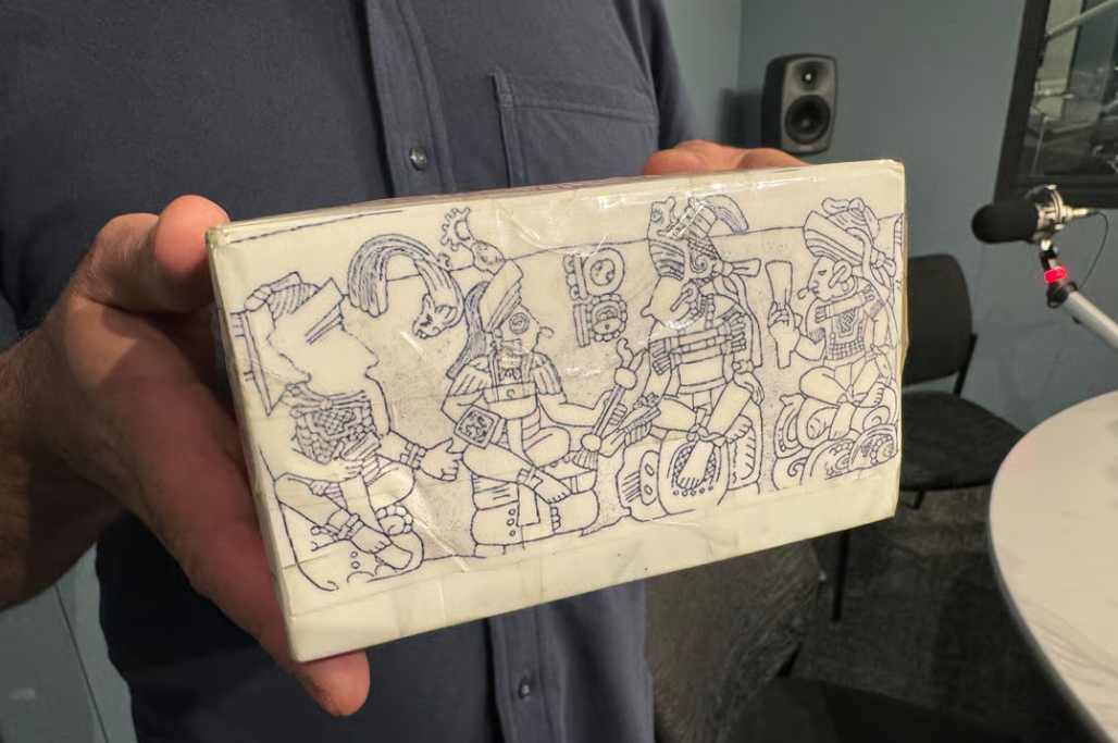 A replica shows distinct hand symbols and imagery from ancient Maya carvings.