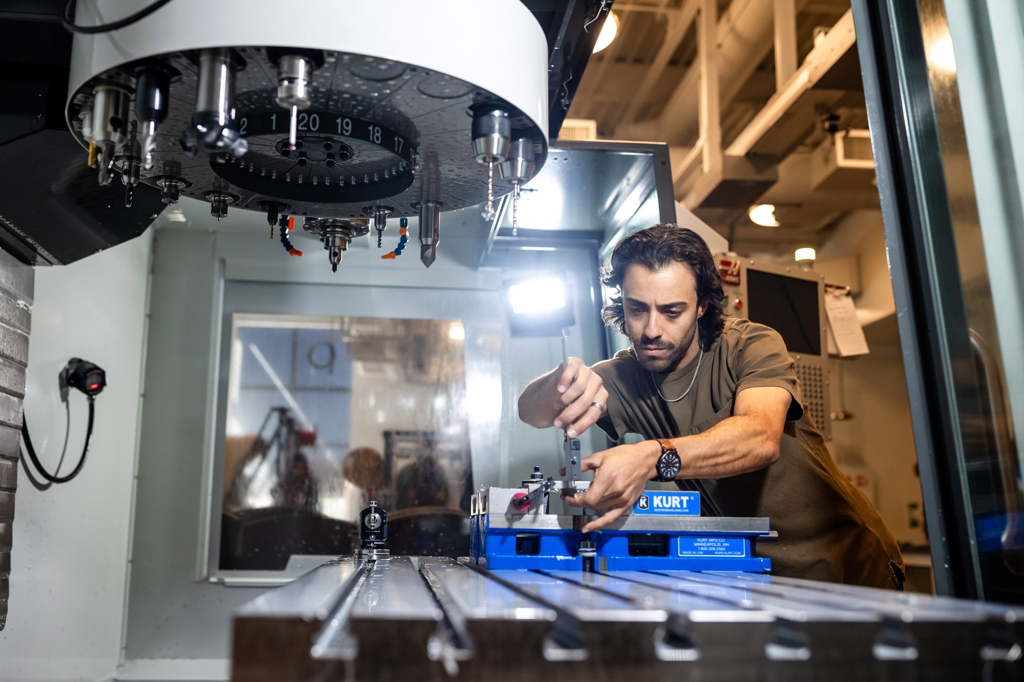 A student working with manufacturing equipment in a shop