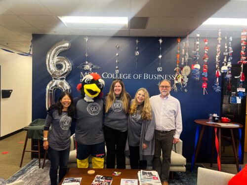 A photo of the CBUS Staff with Rowdy posing in front of their homecoming decorations