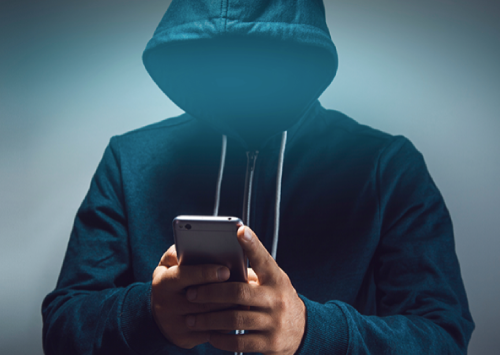 Conceptual image of phone phishing, showing a person in a hoodie holding a phone to represent scam calls