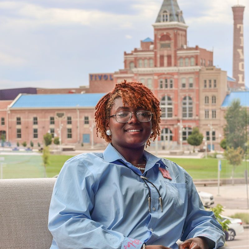 MSU Denver student Sanaa Walker sitting in the Hospitality building overlooking the Tivoli