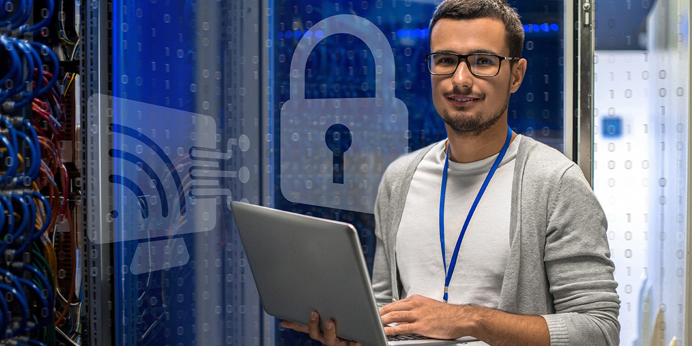 Man working on laptop computer in an IT room