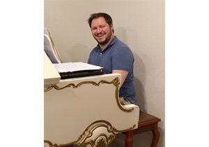 Alex Clarke sitting at a piano