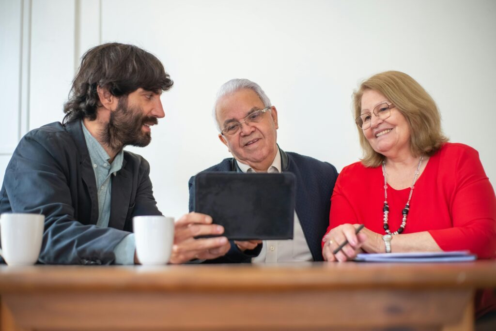 A community health worker consulting with an aging couple sitting down at a desk.