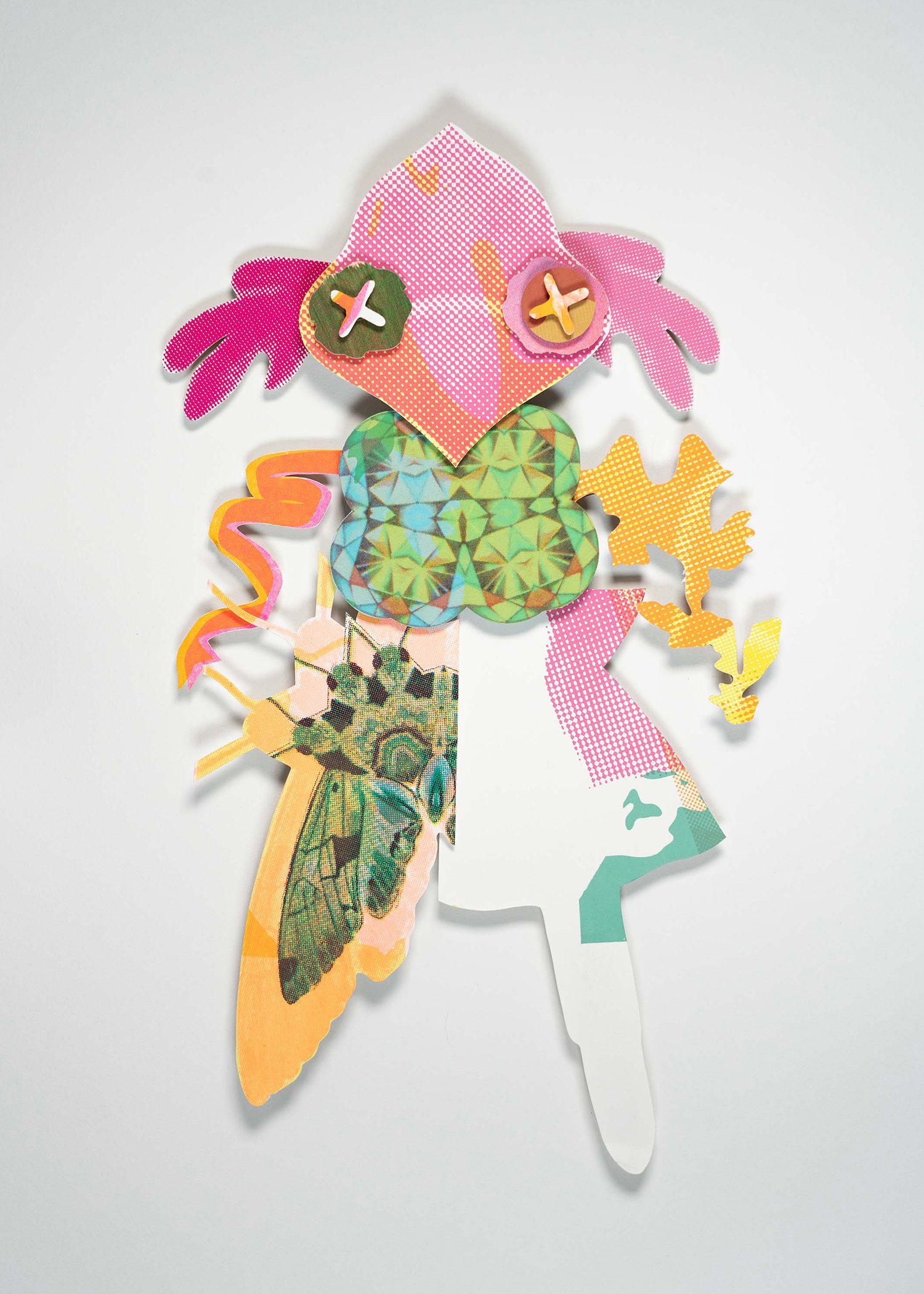 Colorful pieces of printed paper cut and layered into a bug-like shape.