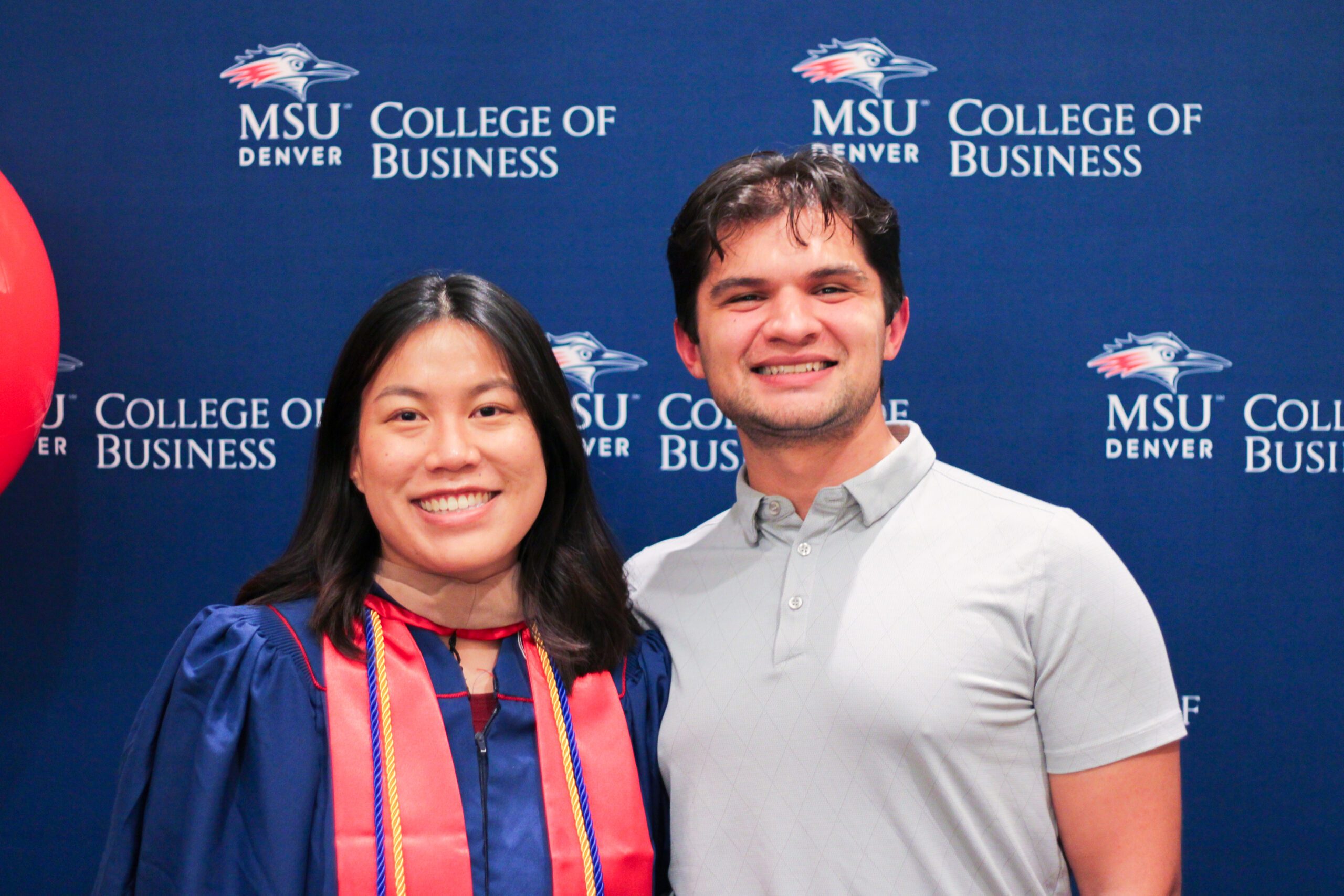 Fall '25 MBa & MPAcc Hooding Celebration - MPAcc grad, Jessica, smiling in regalia with family