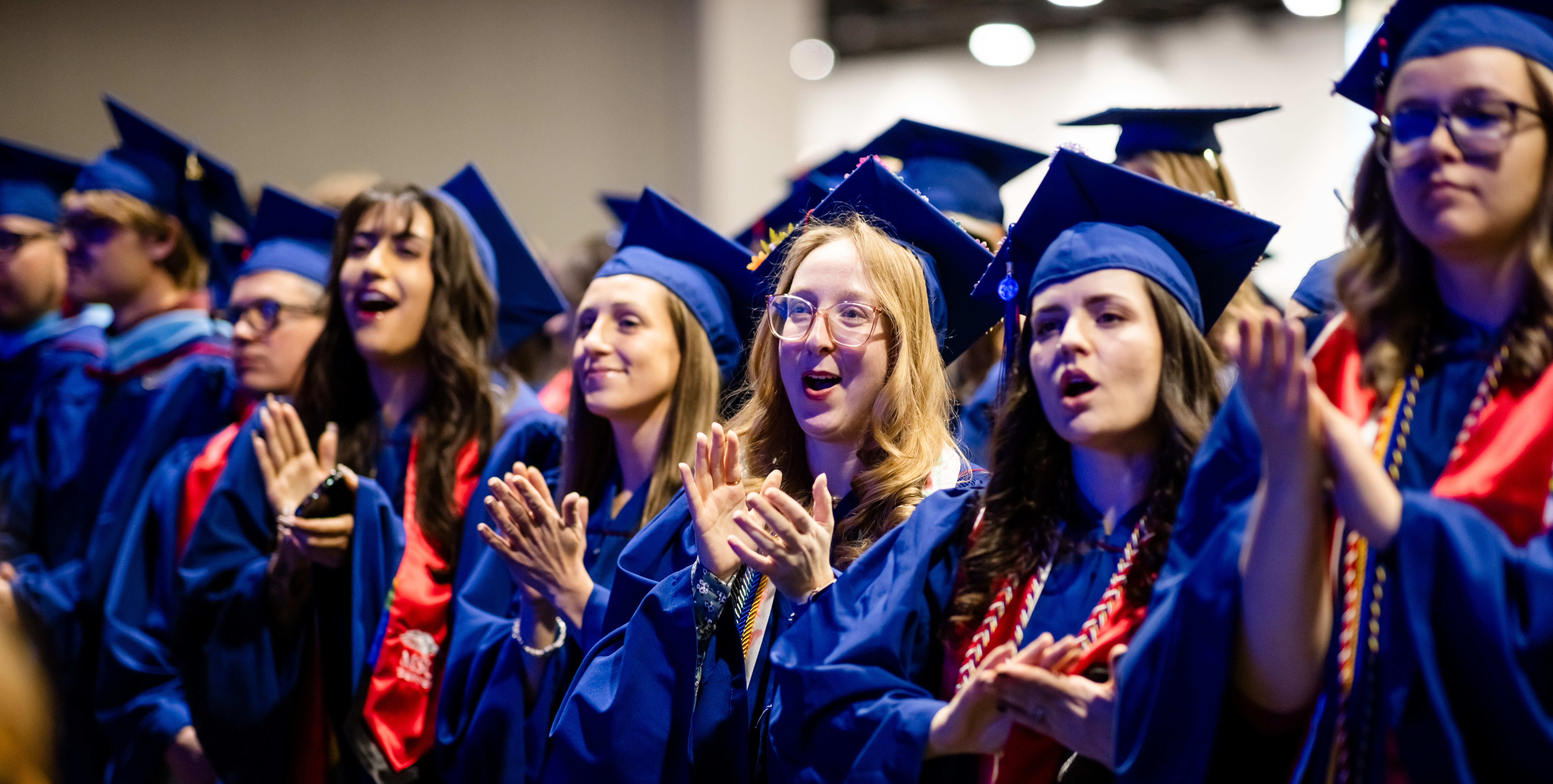 Graduates stand and clap during the Commencement Ceremony.