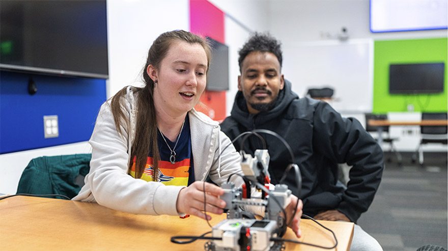 Students Moriah Lane and Desalegn Neme (Right) focus on STEM education as they test code on a LEGO robot. Photo by Josh Gearing