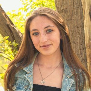 A woman with long, light brown hair wearing a denim jacket