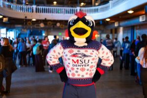 Rowdy in holiday sweater posing for photo.