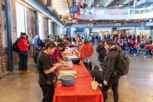 Students at event surrounding table.