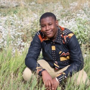 Young man crouching in grass