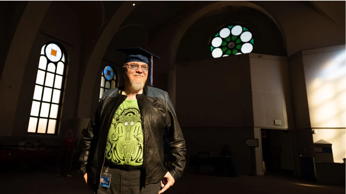 MSU Denver Anthropology student Guy Davis picks up his cap and gown in preparation for Commencement.
