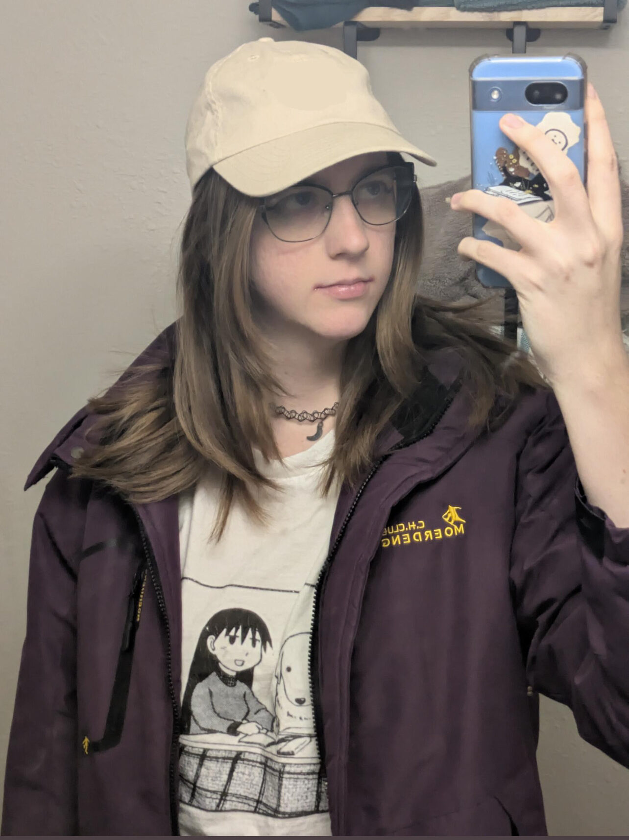 mirror selfie, person wearing a tan hat, glasses, tan t-shirt and dark brown jacket 