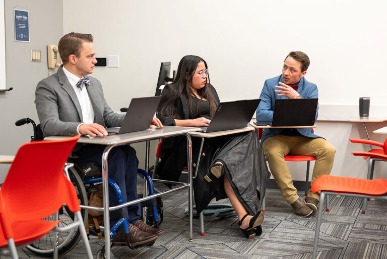 MSU Denver Debate students from left to right: Benjamin Pexton, Alliton Flores Sanchez and Aksel Silva respond to the competing group's counter statements. Photo by Josh Geurink