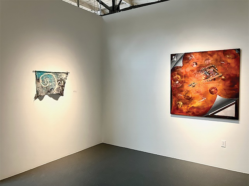 Art gallery corner with a textile piece and an abstract painting on display.