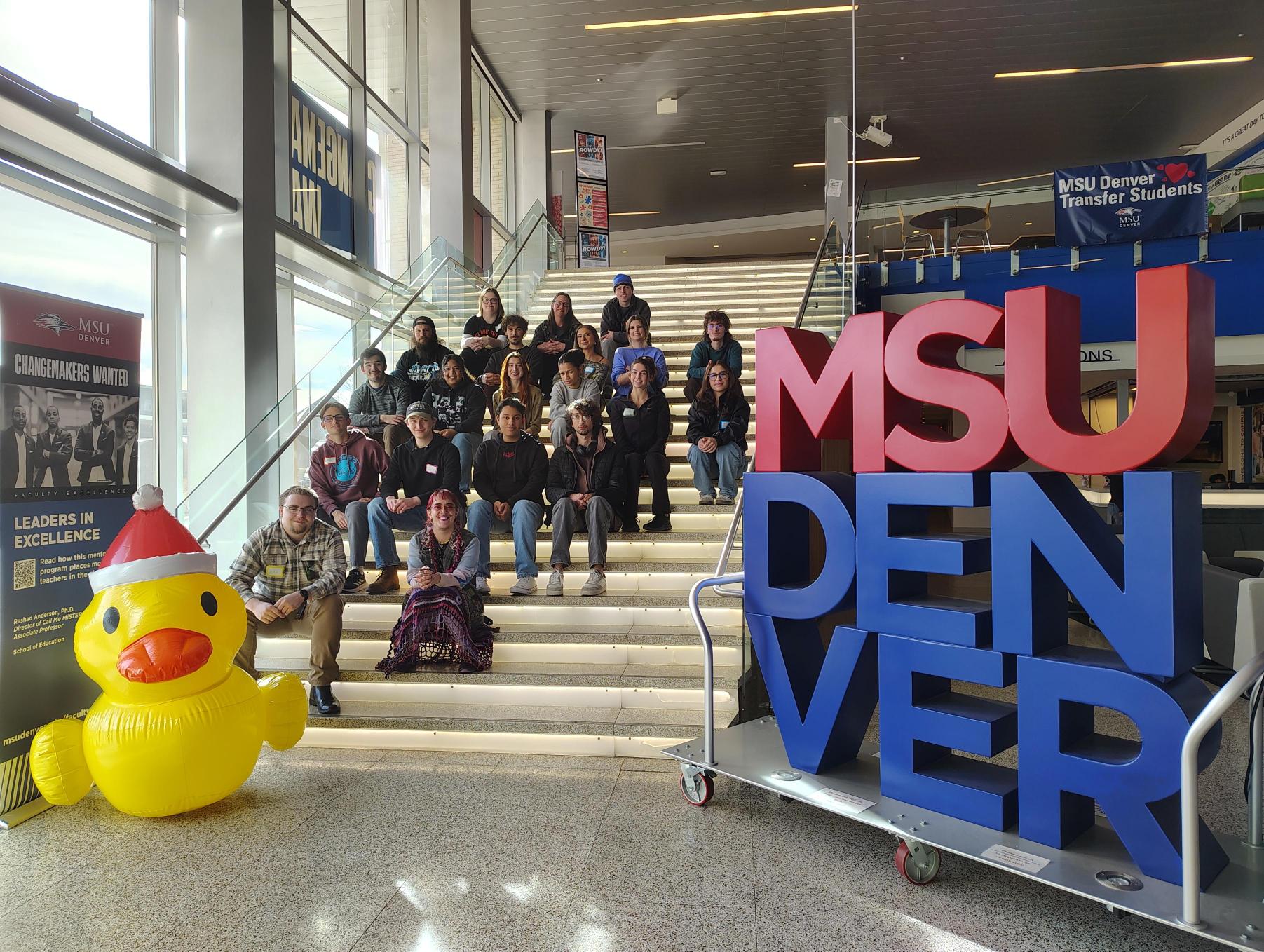 Supplemental Instruction team for Spring 2026 on the JSSB main stairs. The MSU Denver letter statue and a large inflateable duck are also included in the photo.