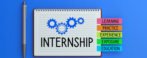 An overhead shot of a spiral notebook on a blue background, with a silver pen to its left. On the notebook's page, three interlocking blue gears are drawn above the word 