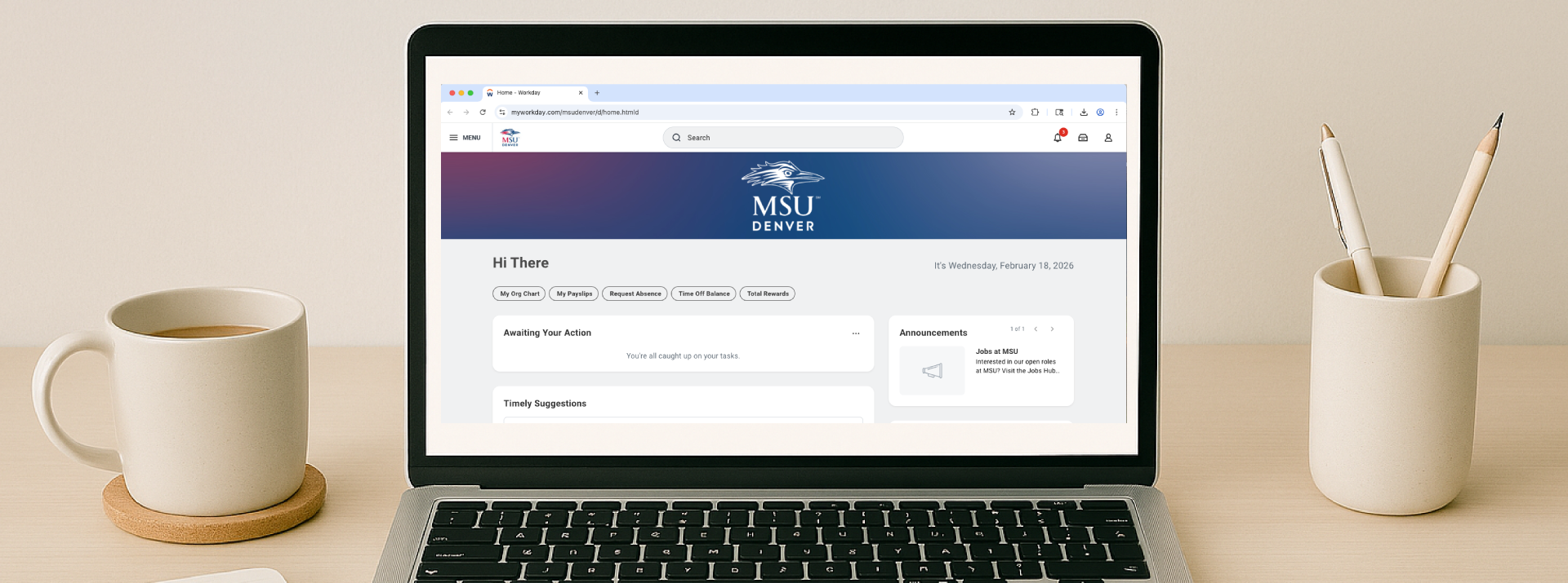 A calm, minimal workspace featuring an open laptop (with the Workday home screen displayed) on a light wood desk, with a notebook and pen on one side and a cup of coffee and a container holding pencils on the other, all set against a soft, neutral background.