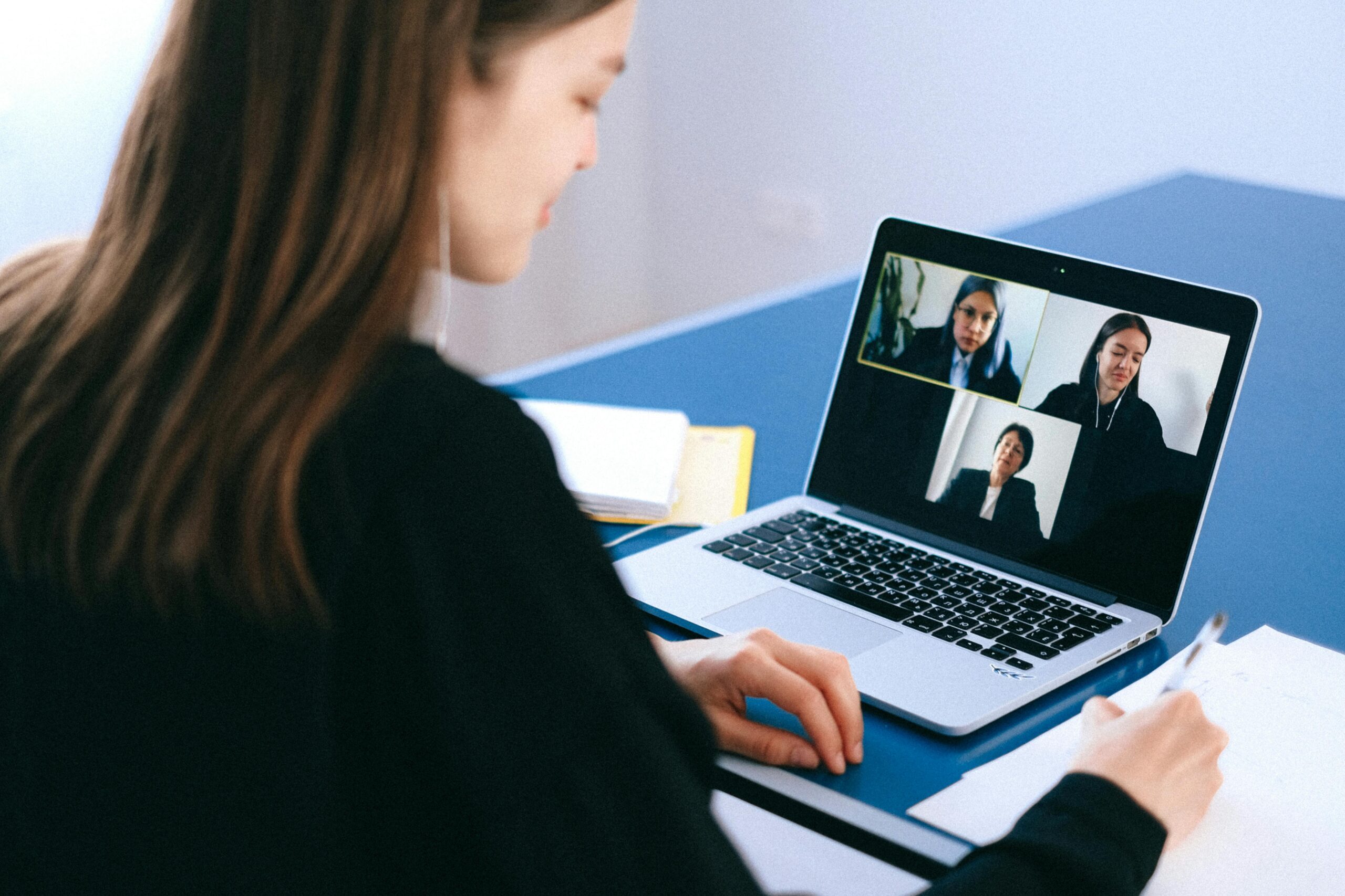 A business woman on a virtual call on a laptop.