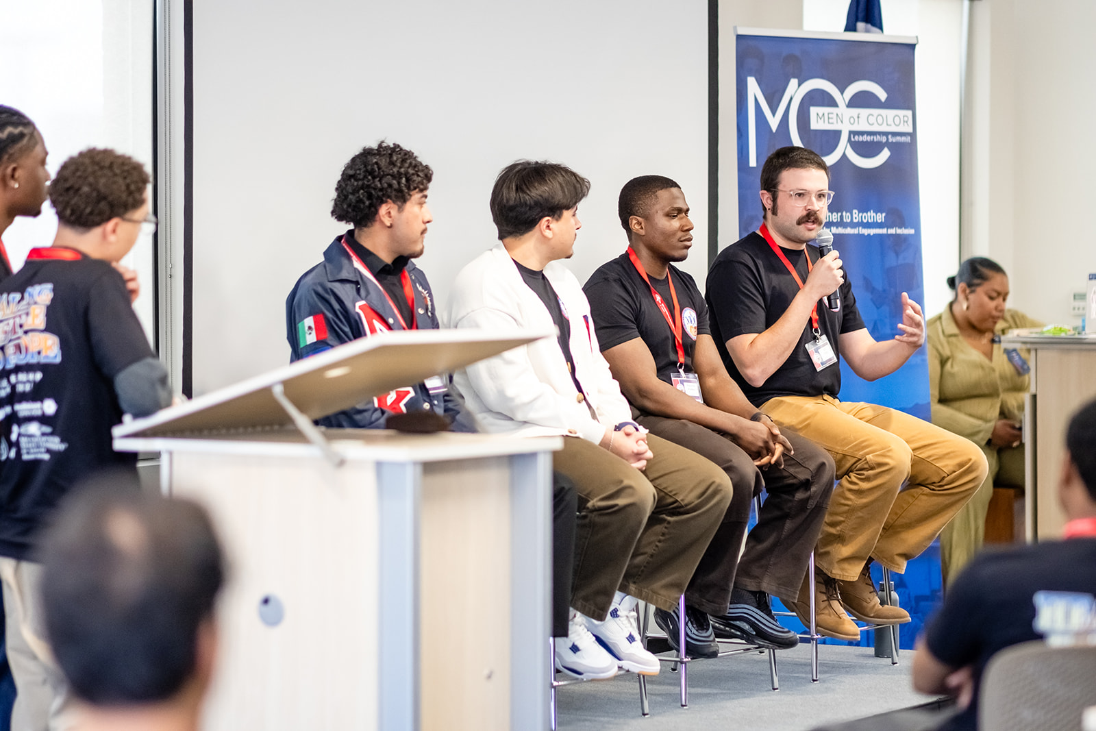 Student panel of students presenting on stage