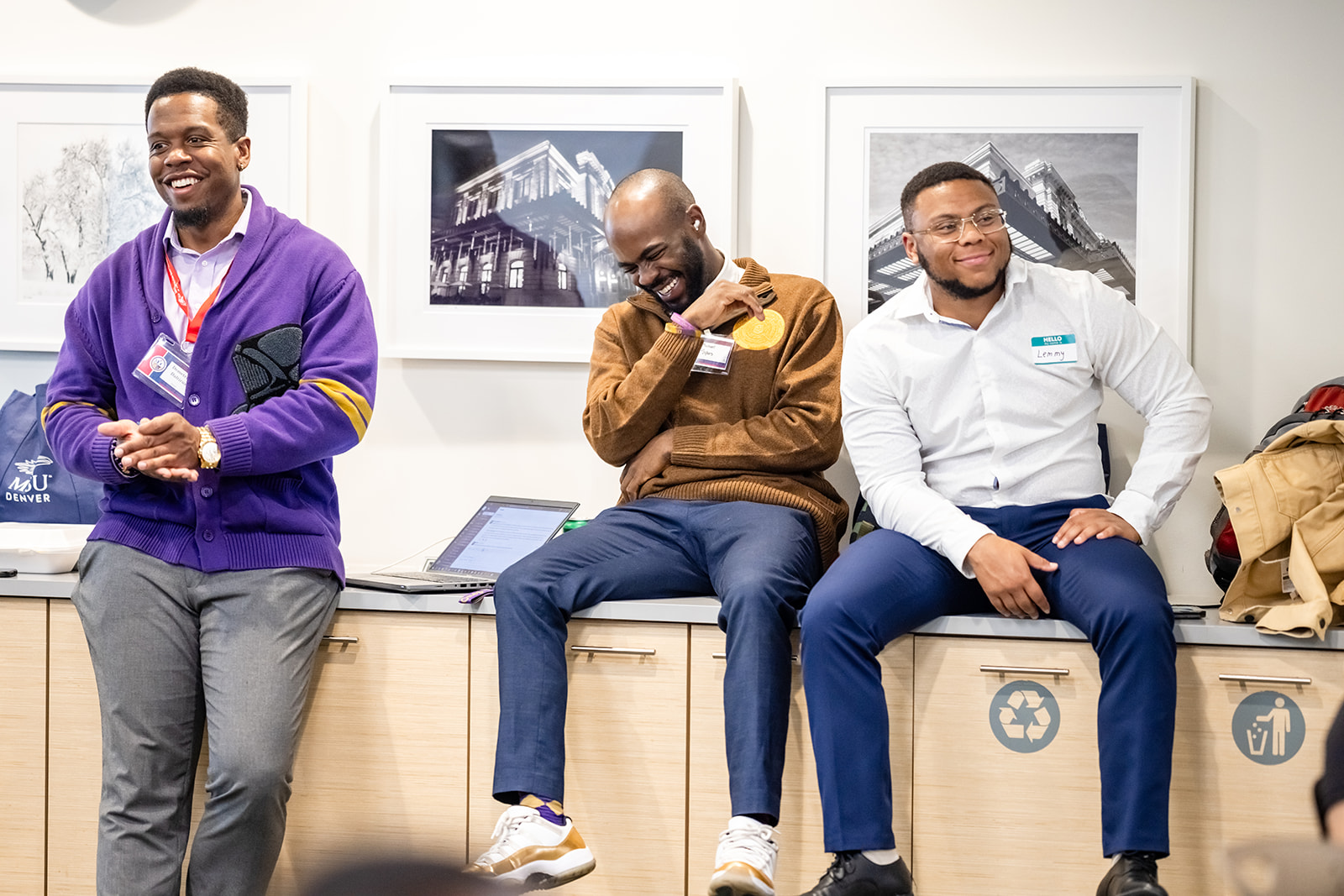 Three students smiling and laughing in a room