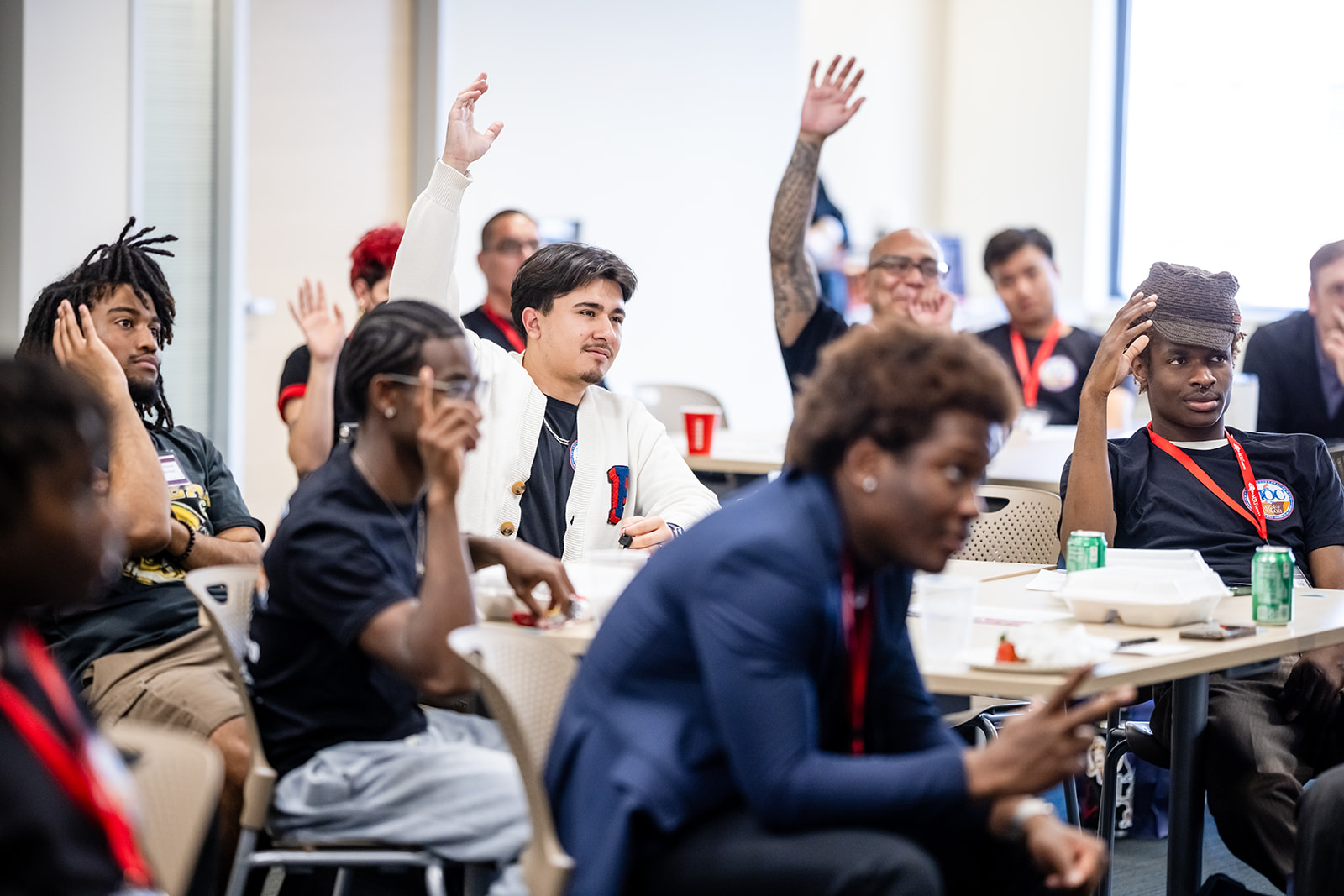 Students raising hands in a room