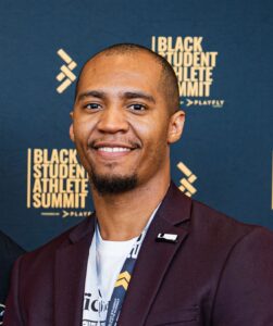 Portrait of a male smiling with a teal background